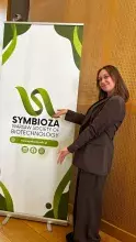 Monika Zielenkiewicz przed banerem konferencji