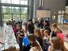 Młodzież szkolna ogląda wystawy kart zielnikowych