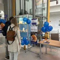 Odwiedzający oglądają wystawę skamieniałości w holu głównym Wydziału Biologii