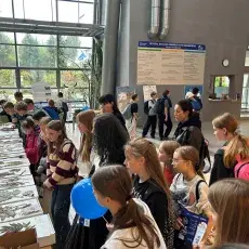 Młodzież szkolna ogląda wystawy kart zielnikowych