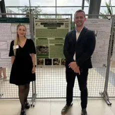 Doktorantka wraz z Promotorem przy swoim posterze